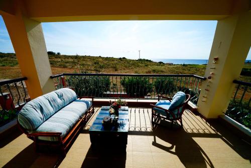 a living room with a couch and a table on a balcony at Apartment Vana in Metamorfosi