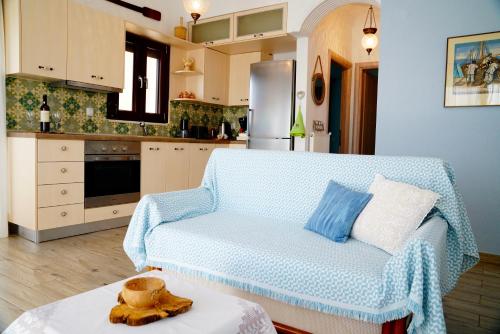 un salon avec un canapé bleu dans une cuisine dans l'établissement Apartment Vana, à Metamórfosi
