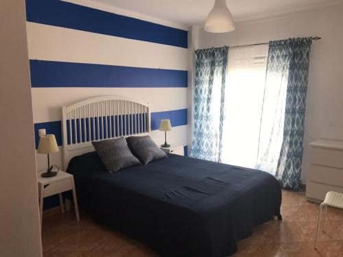 a blue and white bedroom with a bed and a window at Luxury Apartment Silves - Algarve in Silves