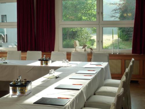 a dining room with a table and chairs and windows at Römerhof in Stuttgart