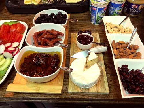 a table topped with bowls of food and other foods at SleepWalker Boutique Suites in Wrocław