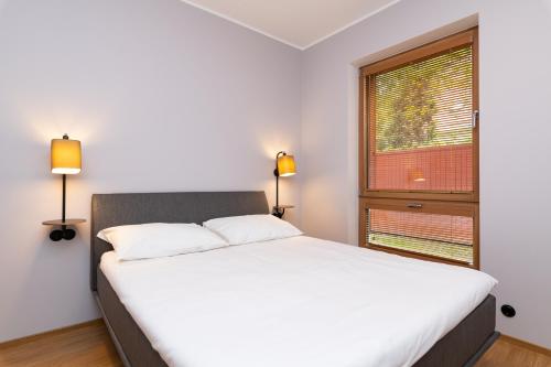 Un dormitorio con una gran cama blanca y una ventana en Self-check-in 2 bedroom apartment with a terrace and free parking en Tallin