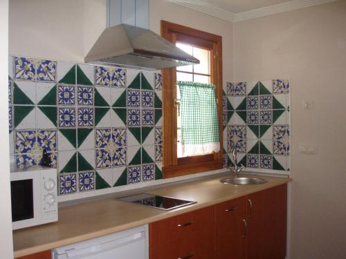 una cucina con piastrelle blu e bianche sul muro di Apartamentos Casa María Juanín a Collanzo