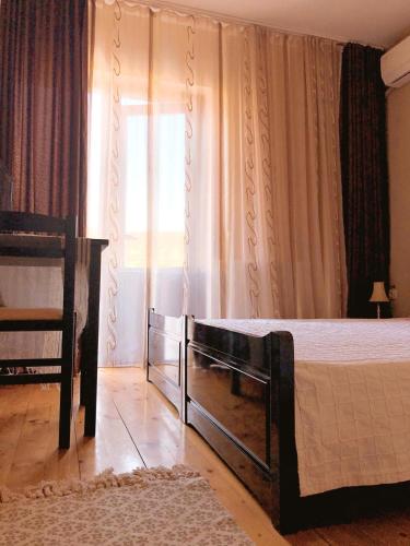 a bedroom with a large bed and a window at Pensiunea Aurelia in Şiria