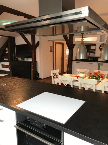 a kitchen with a black counter top with a table at Wieko Ferienwohnungen - Luxus Pur im Prinz von Preußen in Bad Elster