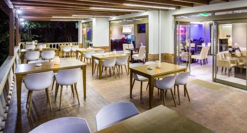 a restaurant with tables and chairs in a room at Garden in Limenaria