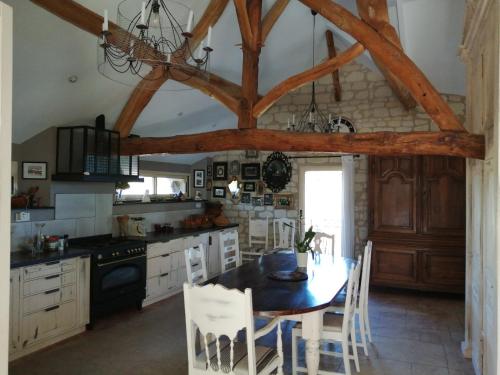 une cuisine avec une table et des chaises dans une pièce dans l'établissement La Motelle N 5, à Les Ulmes