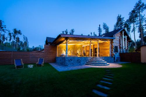 a log cabin with a lawn in front of it at Банний клуб Столичний in Vita-Pochtovaya