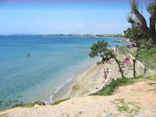 a group of people on a beach near the water at SEASIDE SUNSET WALKS in Athens