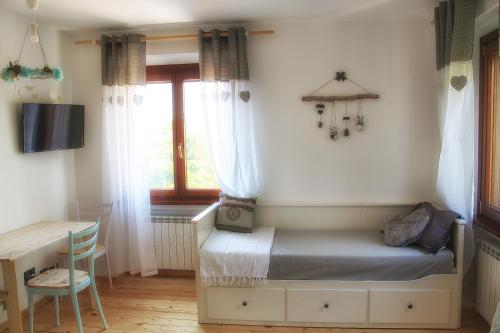 a bedroom with a bed and a desk and a window at Al bosco incantato in Trieste