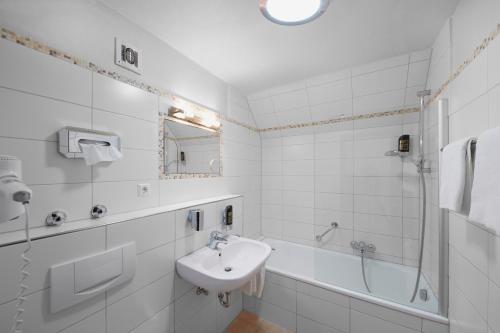 
a bathroom with a sink, toilet and bathtub at Hotel Stadt Tuttlingen in Tuttlingen
