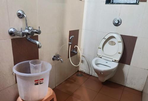 a bathroom with a toilet and a trash can at Rainwood Residency in Lonavala