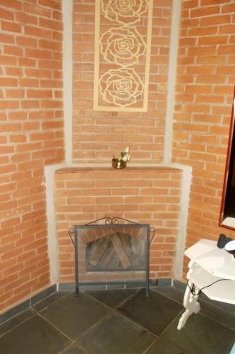 a brick wall with a fireplace in a bathroom at Pousada Nasa in São Bento do Sapucaí