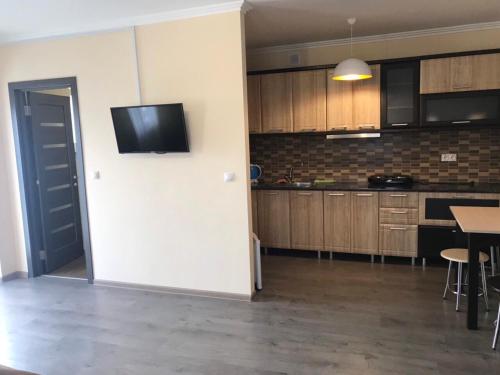 uma cozinha com uma televisão na parede e uma mesa em Modern Apartments em Mukacheve