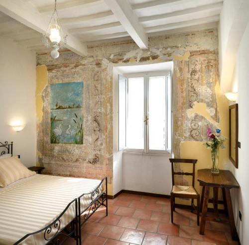 a bedroom with a bed and a window at Hotel Porta Marmorea in Gubbio