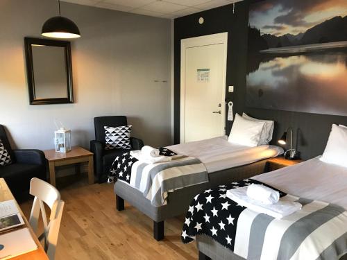 una camera d'albergo con due letti, un tavolo e delle sedie di Port Hotel a Karlshamn