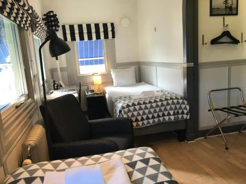 a small room with a bed and a chair at Port Hotel in Karlshamn