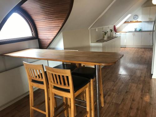 a kitchen with a wooden table and two chairs at Port Hotel in Karlshamn