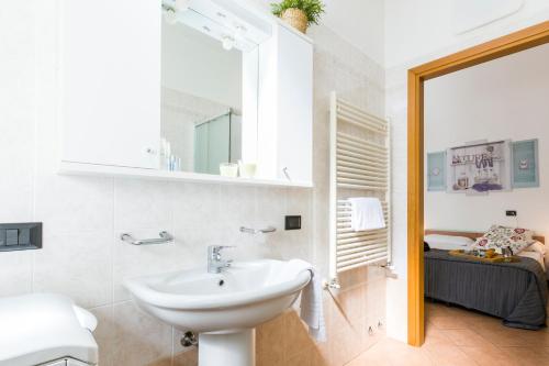 a white bathroom with a sink and a mirror at Casa Temporanea in Bologna