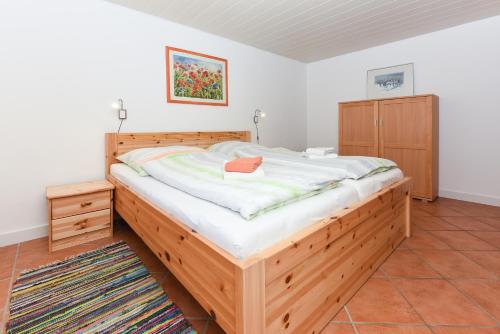 ドルヌマージールにあるFerienhaus Am Deichのベッドルーム1室(大型木製ベッド1台付)