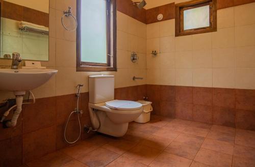 uma casa de banho com um WC e um lavatório em Orchid Trails Resort em Sultan Bathery