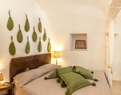 una camera da letto con un letto con cuscini verdi di Alesia luxury suite Ostuni a Ostuni