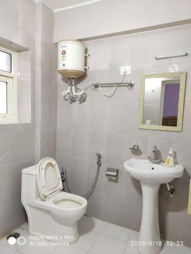 a bathroom with a toilet and a sink at THE HIMALAYAS GUEST HOUSE in Dharamshala