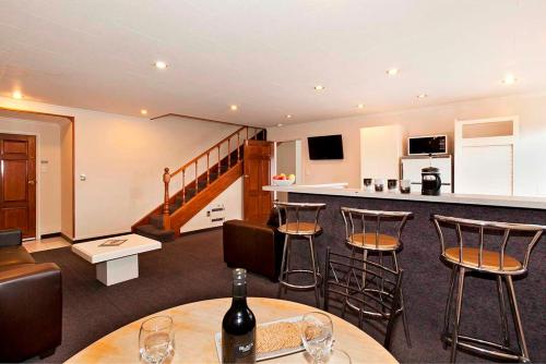 una habitación con bar y algunas sillas y botellas de vino en Colonial Inn Motel, en Christchurch