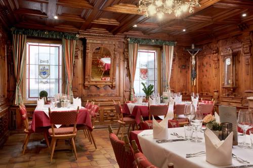 a dining room with tables and chairs and a chandelier at Hotel Neue Post in Mayrhofen