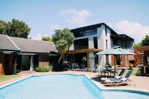 a swimming pool in front of a house at 9 Windsor House in Tokai
