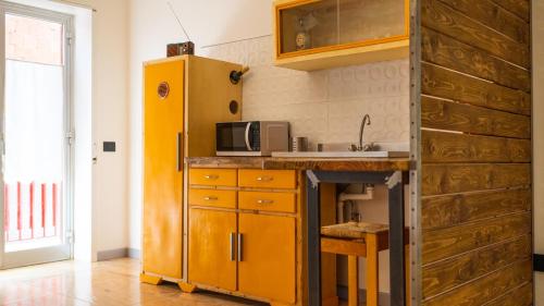 La cuisine est équipée d'un réfrigérateur jaune et d'un four micro-ondes. dans l'établissement B&B Mount Etna, à Belpasso