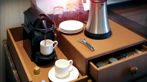a cupboard with a coffee mug and coffee maker at The Retreat Palm Dubai MGallery by Sofitel in Dubai