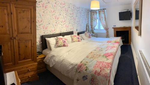 a bedroom with a large bed with floral wallpaper at The Cables in Matlock