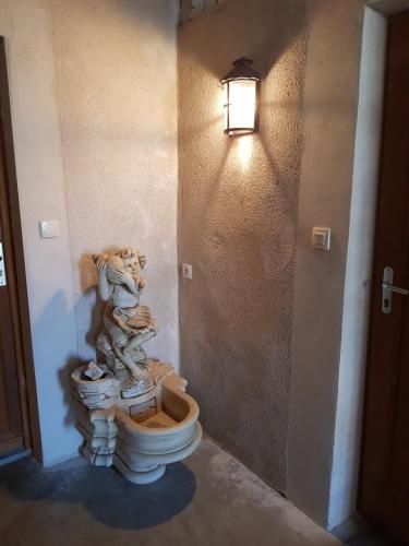 une statue d'ours en peluche assise sur des toilettes dans une pièce dans l'établissement Gîte Micha, à Saint-Lothain