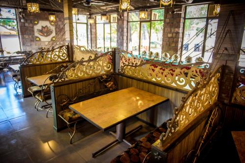 a row of benches in a restaurant with a wooden table at Adamo The Village in Matheran