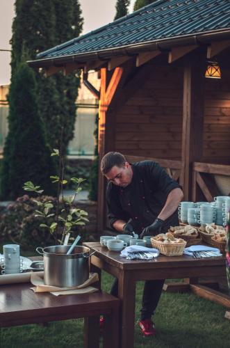a man preparing food on a picnic table at Sofia Hotel in Rivne