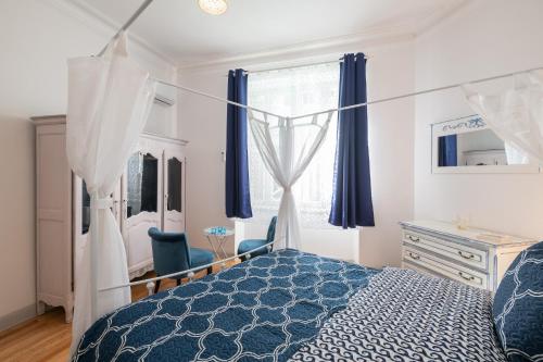ein Schlafzimmer mit einem Bett, einer Kommode und einem Fenster in der Unterkunft Le Beau Rivage in Nizza