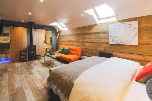 Un dormitorio con una cama y un sofá en una habitación. en An Leti @ Goonwinnow Farm, en Newquay