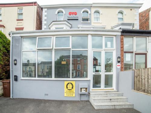 a white building with a large window at OYO Tequila and Dunlin Rooms Southport Central in Southport