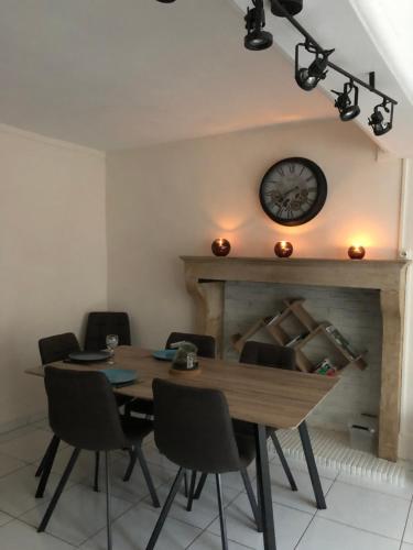 une salle à manger avec une table et une horloge au mur dans l'établissement Bâtisse du pont pinard et son granit rose, à Semur-en-Auxois
