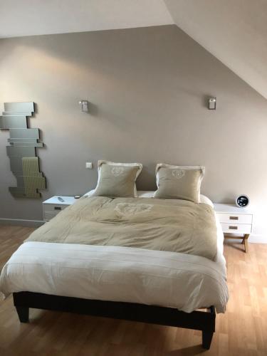 - une chambre avec un grand lit aux murs blancs dans l'établissement Bâtisse du pont pinard et son granit rose, à Semur-en-Auxois