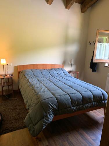 a bedroom with a bed with a blue blanket on it at Can Marc de Pi, Bellver de Cerdanya in Pi