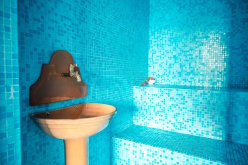a blue tiled bathroom with a toilet and a tub at Mansarda Relax Wellness Gym & Spa in Taormina