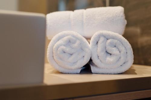 una pila de toallas enrolladas sobre una mesa con papel higiénico en Hotel Post, en Nauders