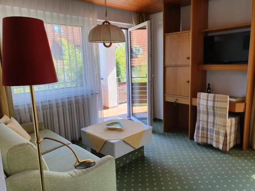 a living room with a couch and a table and a lamp at Hotel Gasthaus Adler in Glottertal