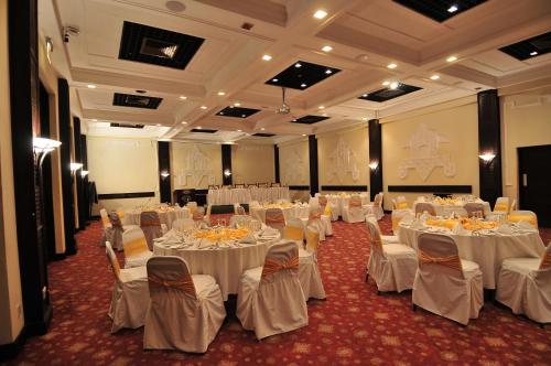 a banquet hall with white tables and chairs at Mombasa Continental Resort in Shanzu