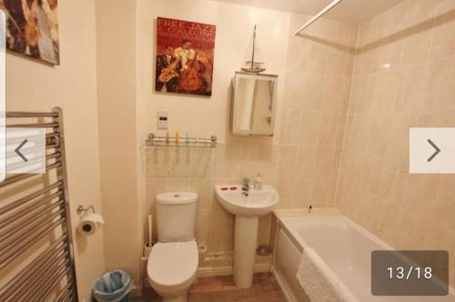 a bathroom with a toilet and a sink and a tub at island reach in Poole