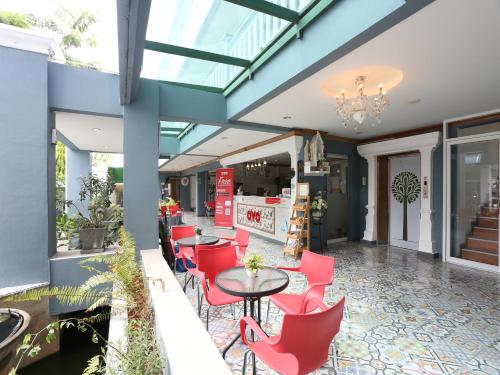 a patio with red chairs and tables in a building at The Lilly Hotel in Chiang Mai