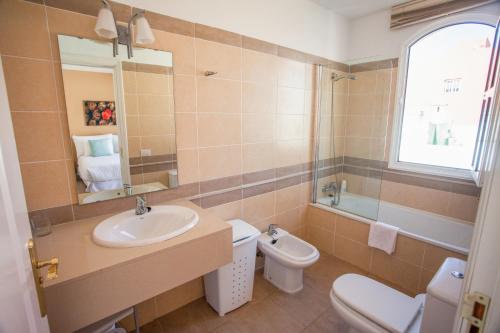 a bathroom with a sink and a toilet and a mirror at Coral Los Silos - Your Natural Accommodation Choice in Los Silos