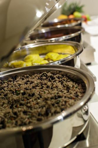 a row of metal trays filled with food at Wyndham Garden San Jose Escazu, Costa Rica in San José